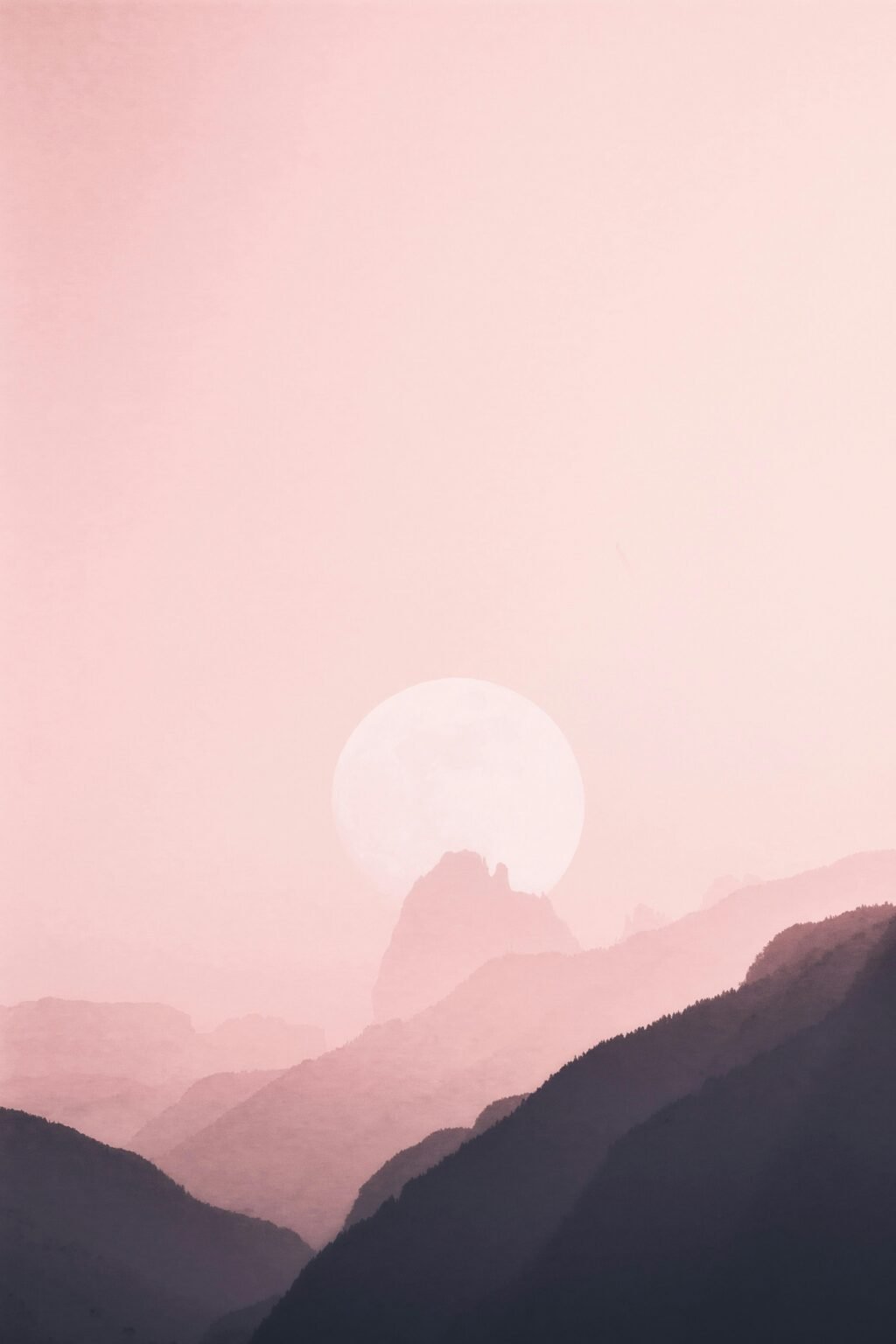Gentle moonrise casting a soft glow over misty mountain ranges, creating a tranquil and calming scene.